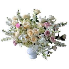 Cream and pink roses with white orchids in a white vase