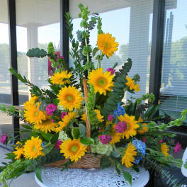 Basket arrangement with yellow sunflowers and mixed greenery