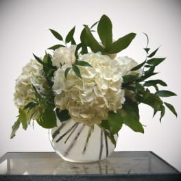 White hydrangea and rose arrangement in a clear glass vase