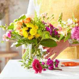 Two colorful flower bouquets in glass vases on a table