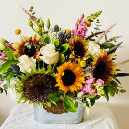 Sunflower and white rose arrangement in a metal container