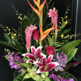 Tropical floral arrangement with pink lilies, roses, and orchids