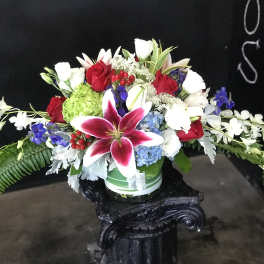 Mixed bouquet with red roses, white lilies, and a pink stargazer lily in a vase