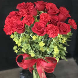 Red roses and carnations in a bouquet with a red ribbon