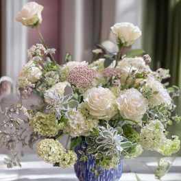 White roses and pale blooms in a blue vase