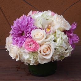 Pink, white, and purple flower arrangement in a dark vase