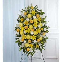 Standing floral spray with yellow and white flowers on an easel