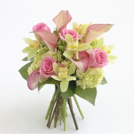 Pink roses and calla lilies arranged with pale green orchids