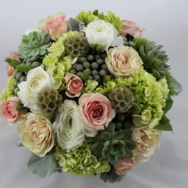 Round bouquet of pale roses, white blooms, and succulents