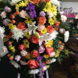 Large standing floral spray with roses, lilies, and daisies