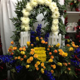 Floral funeral wreath with white blooms and yellow and blue flowers