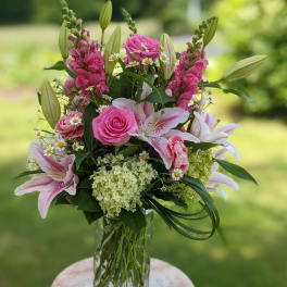 Pink and white floral arrangement in a clear glass vase