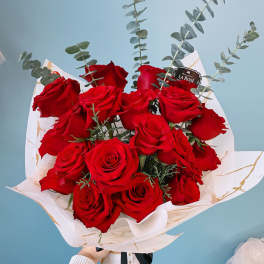 Bouquet of red roses with eucalyptus in white wrap