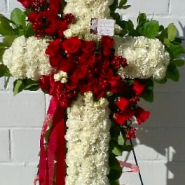 Cross-shaped floral tribute with red roses and white carnations