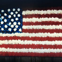 Floral arrangement shaped like the American flag in red, white, and blue
