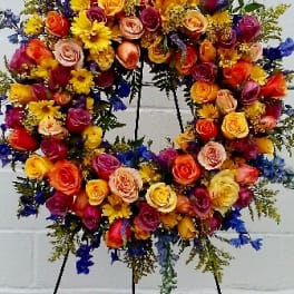 Colorful floral wreath on a stand with roses and daisies