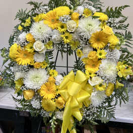 Yellow and white floral wreath with a large yellow bow