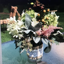 Mixed floral arrangement in a glass vase with white blooms and pink accents