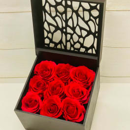 Square black gift box of nine red roses with an open decorative lid