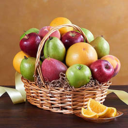 Basket of assorted fruit with orange slices on a plate