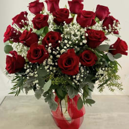 Bouquet of red roses with baby's breath in a glass vase