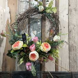 Floral wreath with pink and cream blooms on a twig base