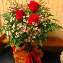 Bouquet of red roses and small pink-white blossoms in a vase
