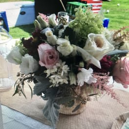 Mixed floral centerpiece with pink and white blooms in a low container