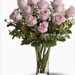 Bouquet of pale pink roses in a clear glass vase