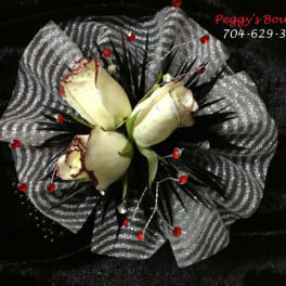 White rose bouquet with silver mesh wrap and red accents