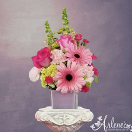 Pink gerberas and roses arranged in a square vase