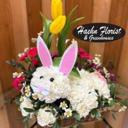 Basket arrangement with a bunny face, pink ears, and yellow tulips