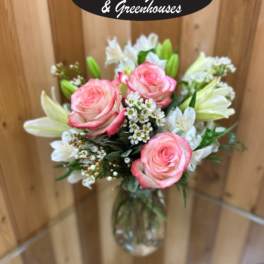 Pink roses and white lilies in a clear glass vase