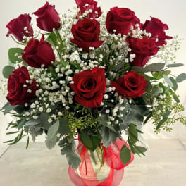 Bouquet of red roses with baby's breath in a glass vase