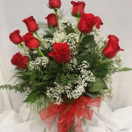 Bouquet of red roses with baby's breath in a glass vase