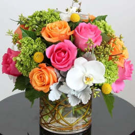 Colorful bouquet of roses and orchids in a glass vase