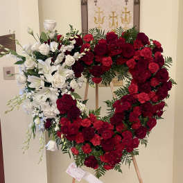 Heart-shaped floral wreath of red and white roses on an easel
