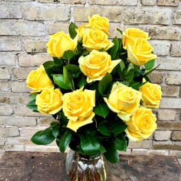 Yellow roses arranged in a clear glass vase