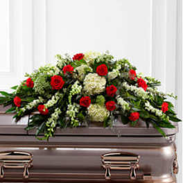 Red roses and white flowers arranged on a casket