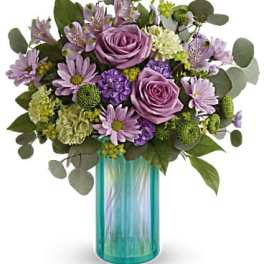 Lavender and purple bouquet in a turquoise glass vase