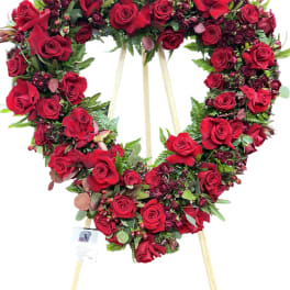 Heart-shaped red rose wreath on a wooden easel