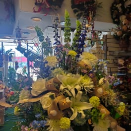 Large mixed floral arrangement in a white vase with lilies and roses