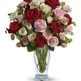Bouquet of red, pink, and white roses in a clear glass vase