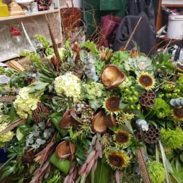 Large tropical floral arrangement with sunflowers, hydrangeas, and green accents