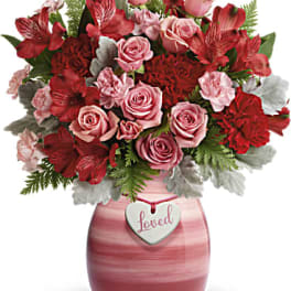 Pink and red rose bouquet in a pink vase with a heart tag