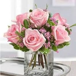 Pink roses arranged in a clear glass vase