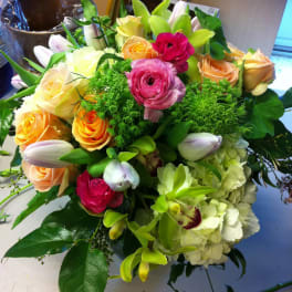 Bouquet of roses, tulips, orchids, and hydrangeas in pink, peach, and green