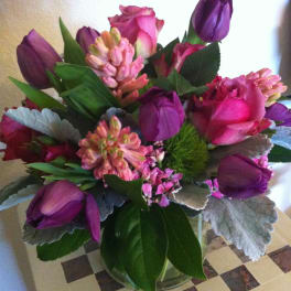 Bouquet of pink roses and purple tulips in a glass vase
