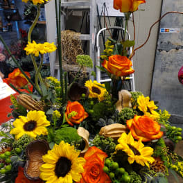Orange roses and yellow sunflowers arranged in a dense floral display