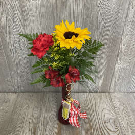 Red and yellow flower arrangement in a burgundy vase with a gingham ribbon